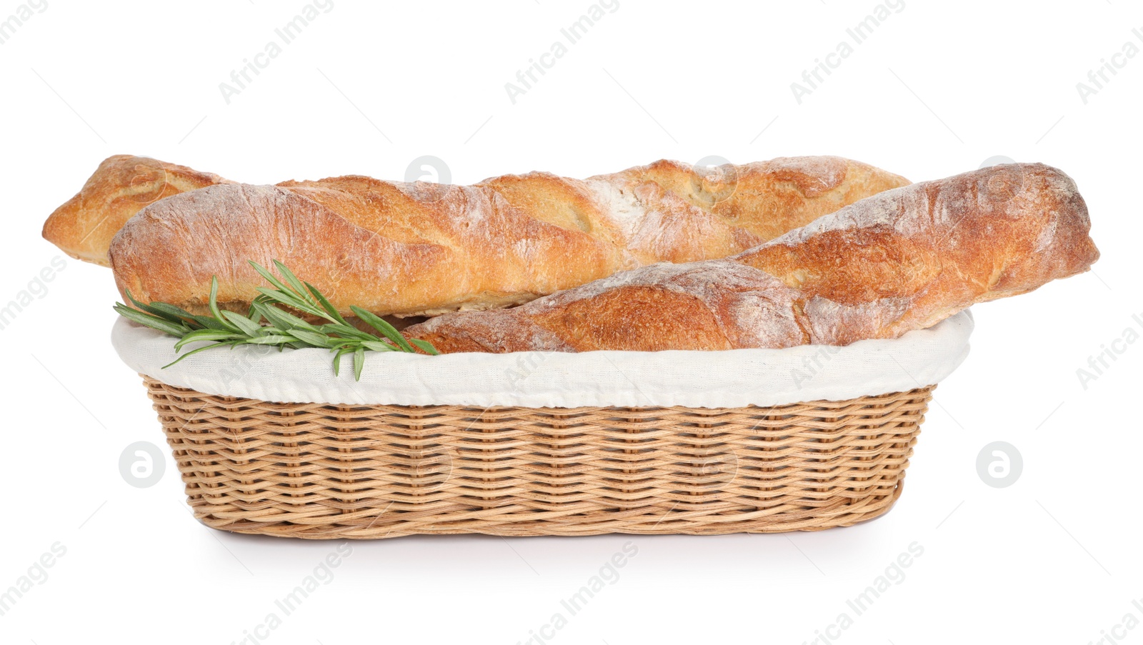 Photo of Crispy French baguettes with rosemary in wicker basket on white background. Fresh bread