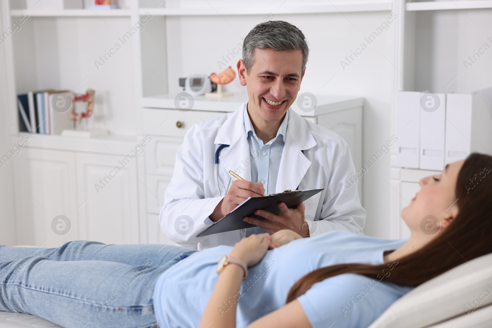 Photo of Gastroenterologist with clipboard consulting patient in clinic