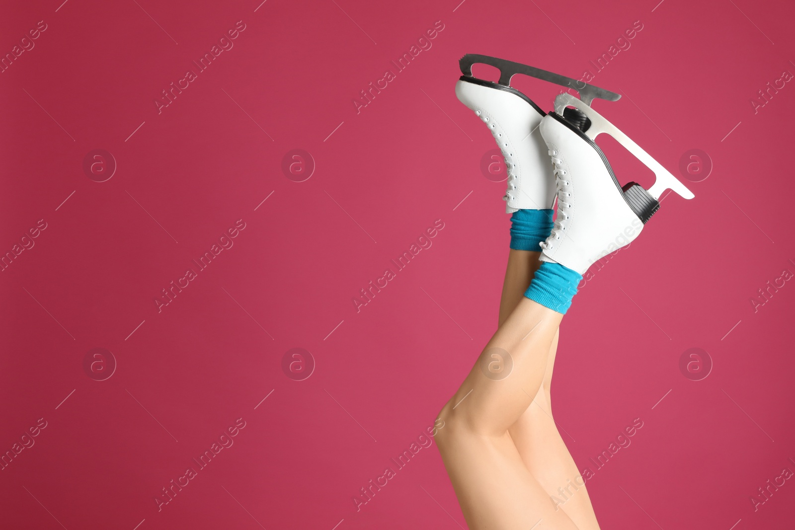 Photo of Woman in elegant white ice skates on pink background, closeup of legs. Space for text