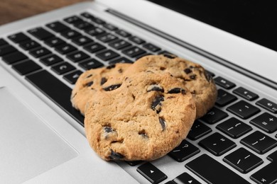 Photo of Chocolate chip cookies on laptop, closeup view