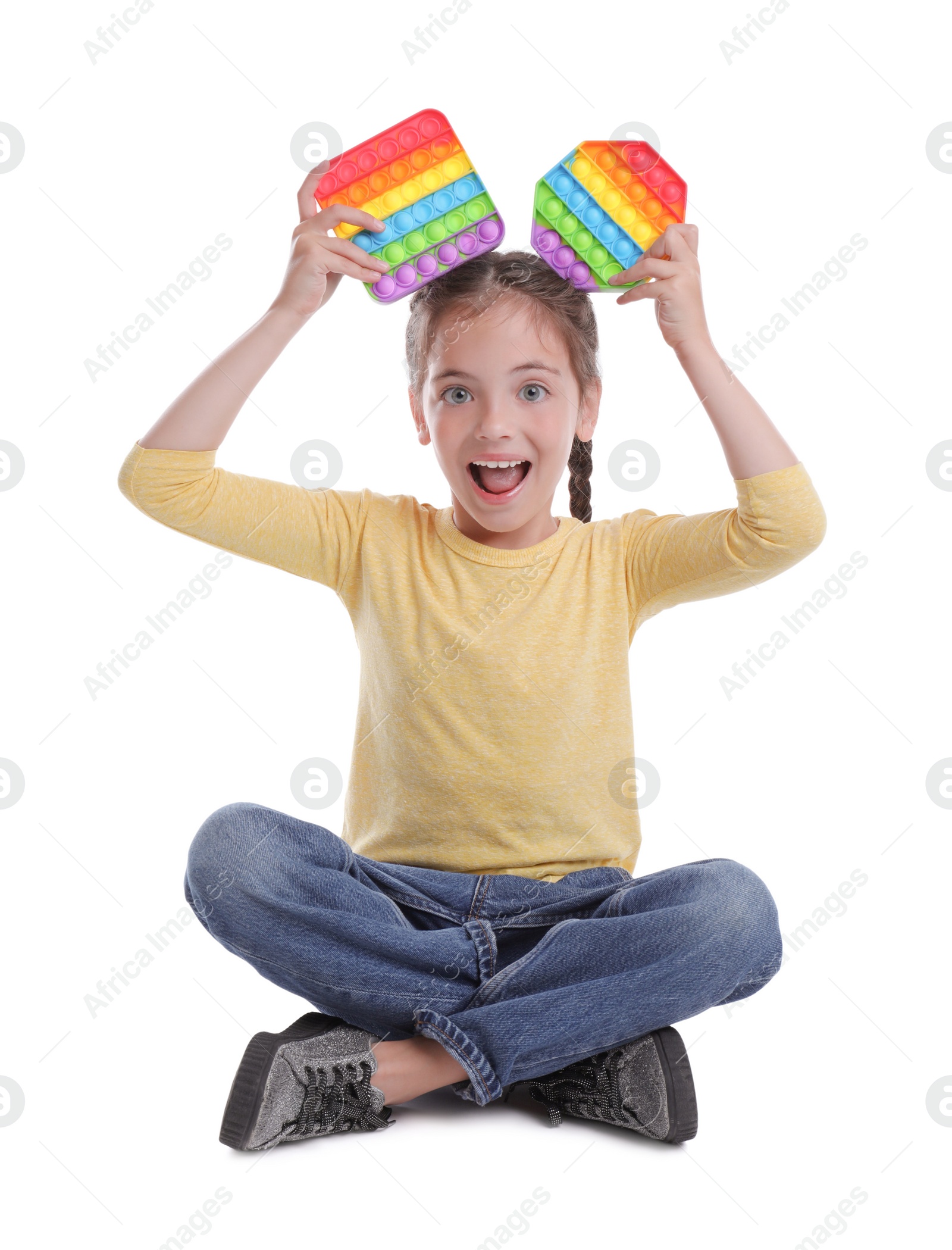 Photo of Little girl with pop it fidget toys on white background