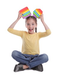 Little girl with pop it fidget toys on white background