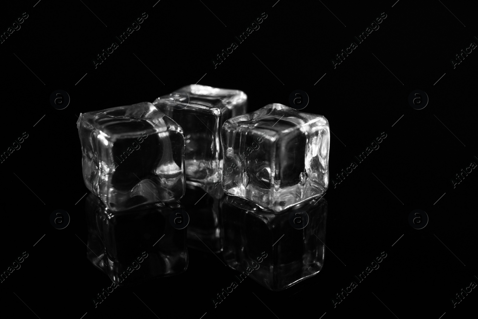 Photo of Pile of crystal clear ice cubes on black background