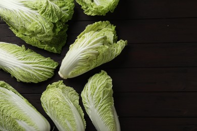Photo of Fresh ripe Chinese cabbages on dark wooden table, fat lay. Space for text
