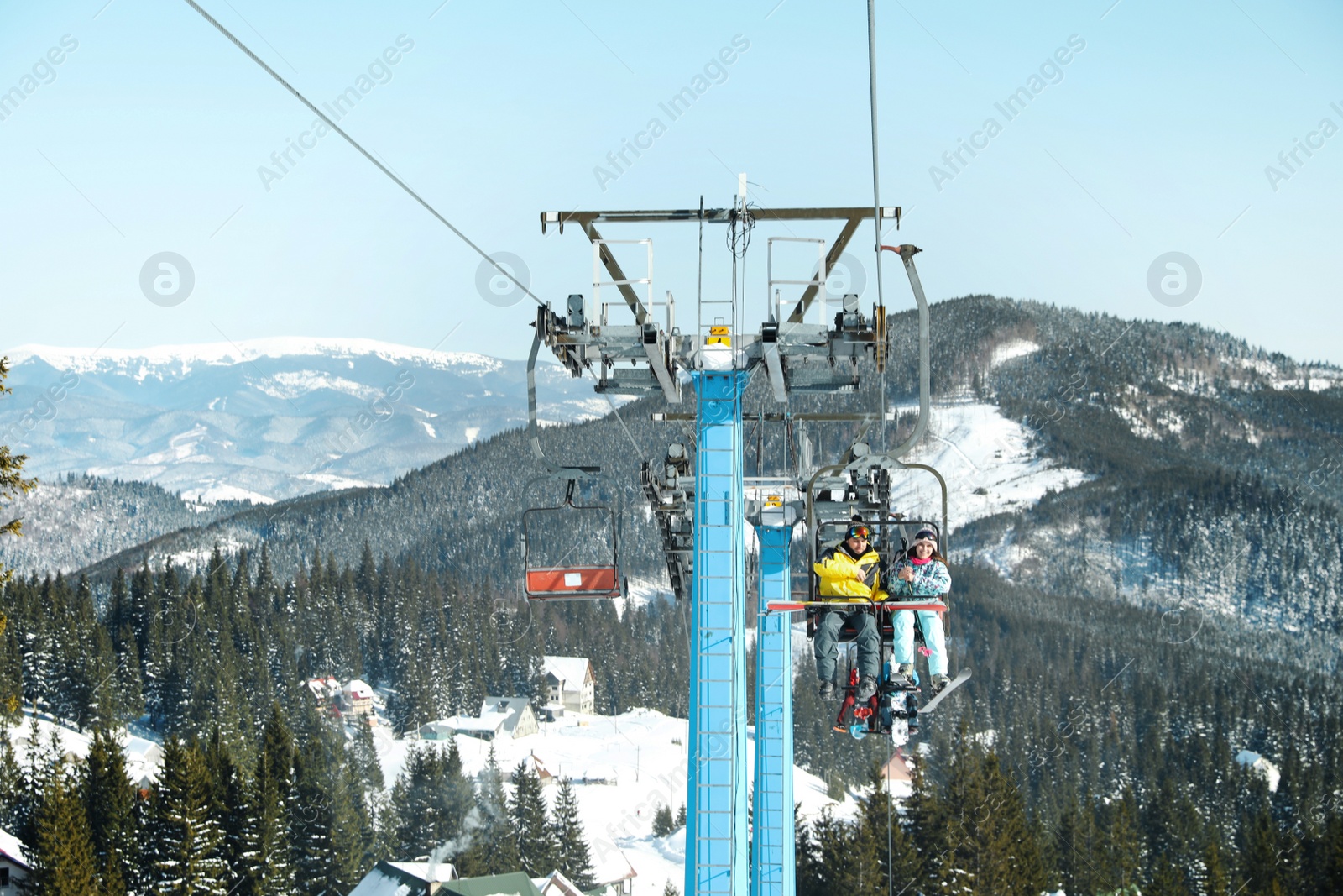 Photo of People using chairlift at mountain ski resort. Winter vacation