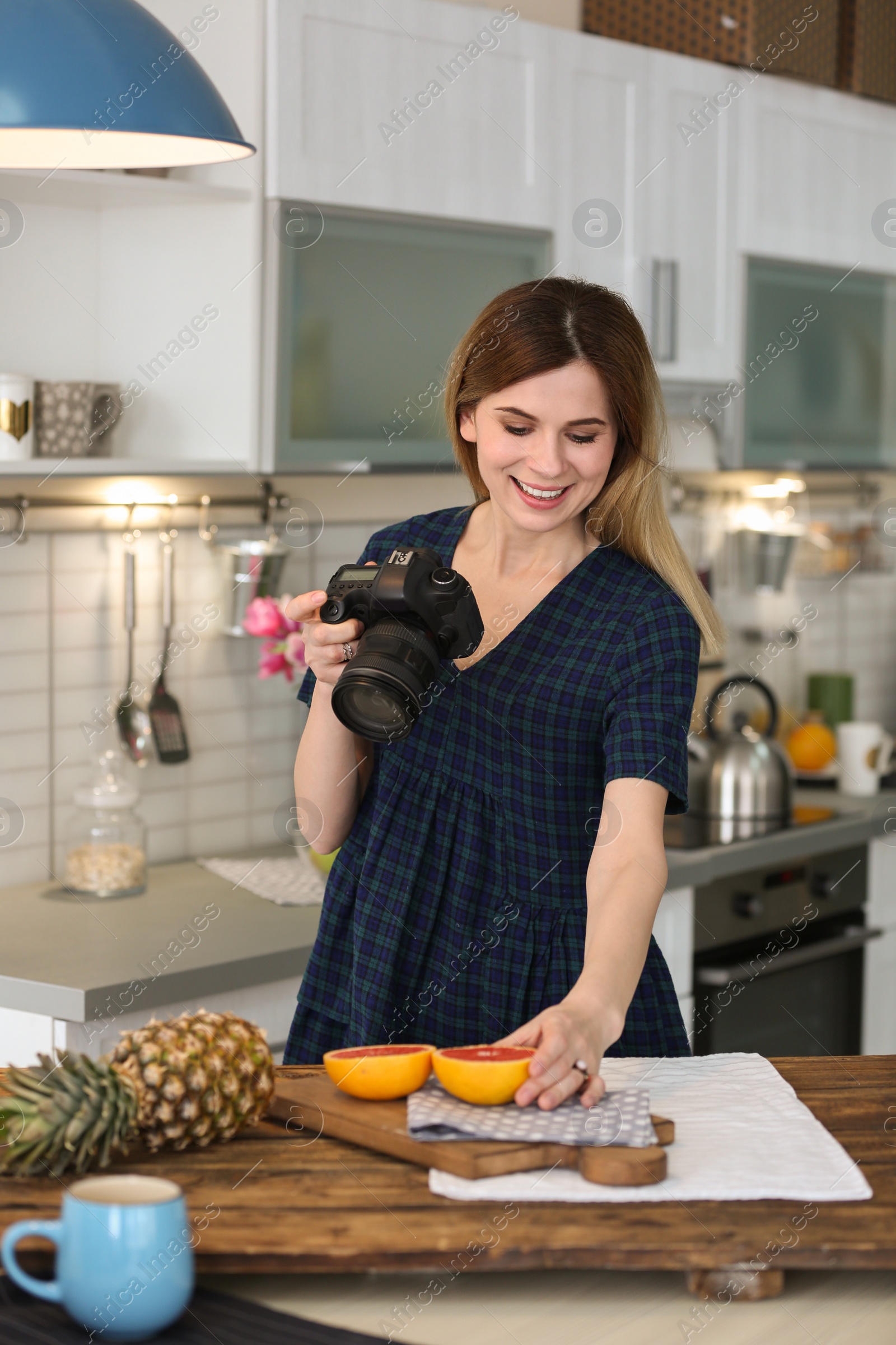 Photo of Young blogger taking photo of food in kitchen