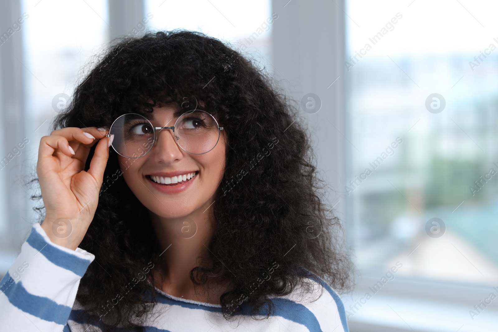 Photo of Portrait of beautiful woman in glasses indoors. Attractive lady smiling and posing for camera. Space for text