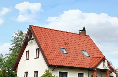 Photo of Modern house with red roof against blue sky