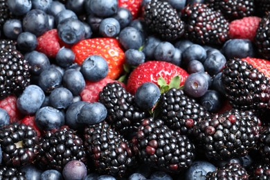 Photo of Mix of different ripe tasty berries as background, closeup view