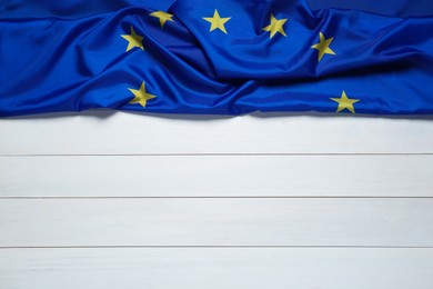 Flag of European Union on white wooden background, top view. Space for text