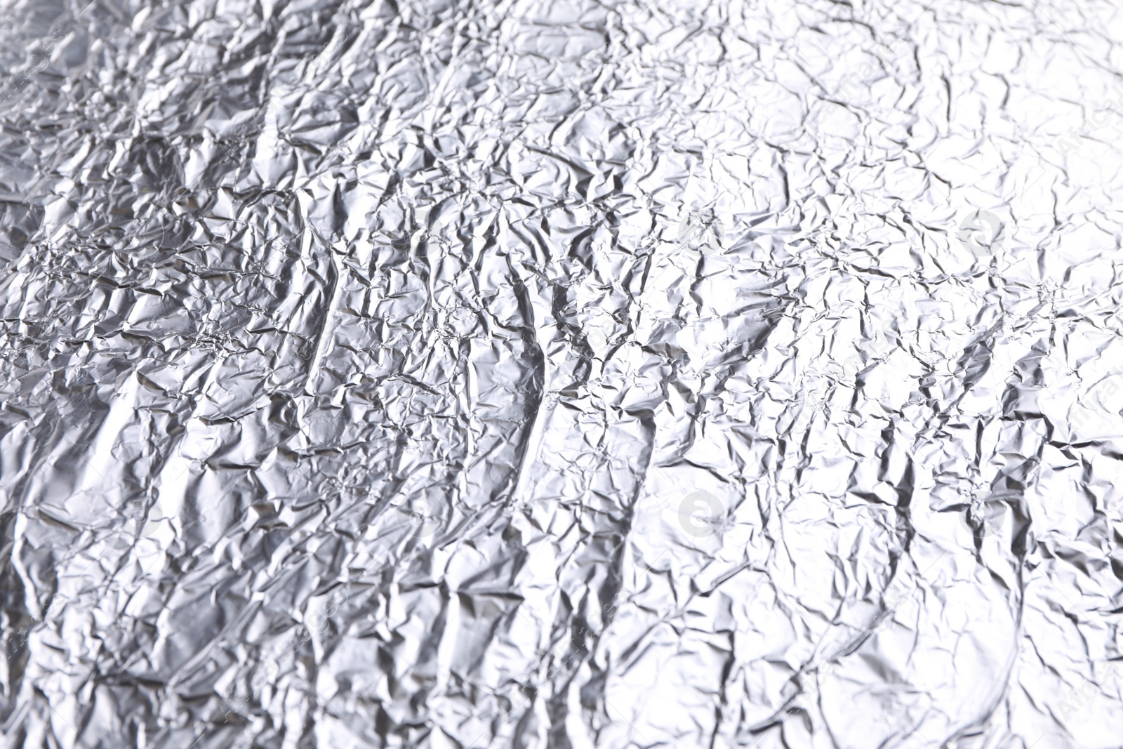 Photo of Crumpled silver foil as background, closeup view