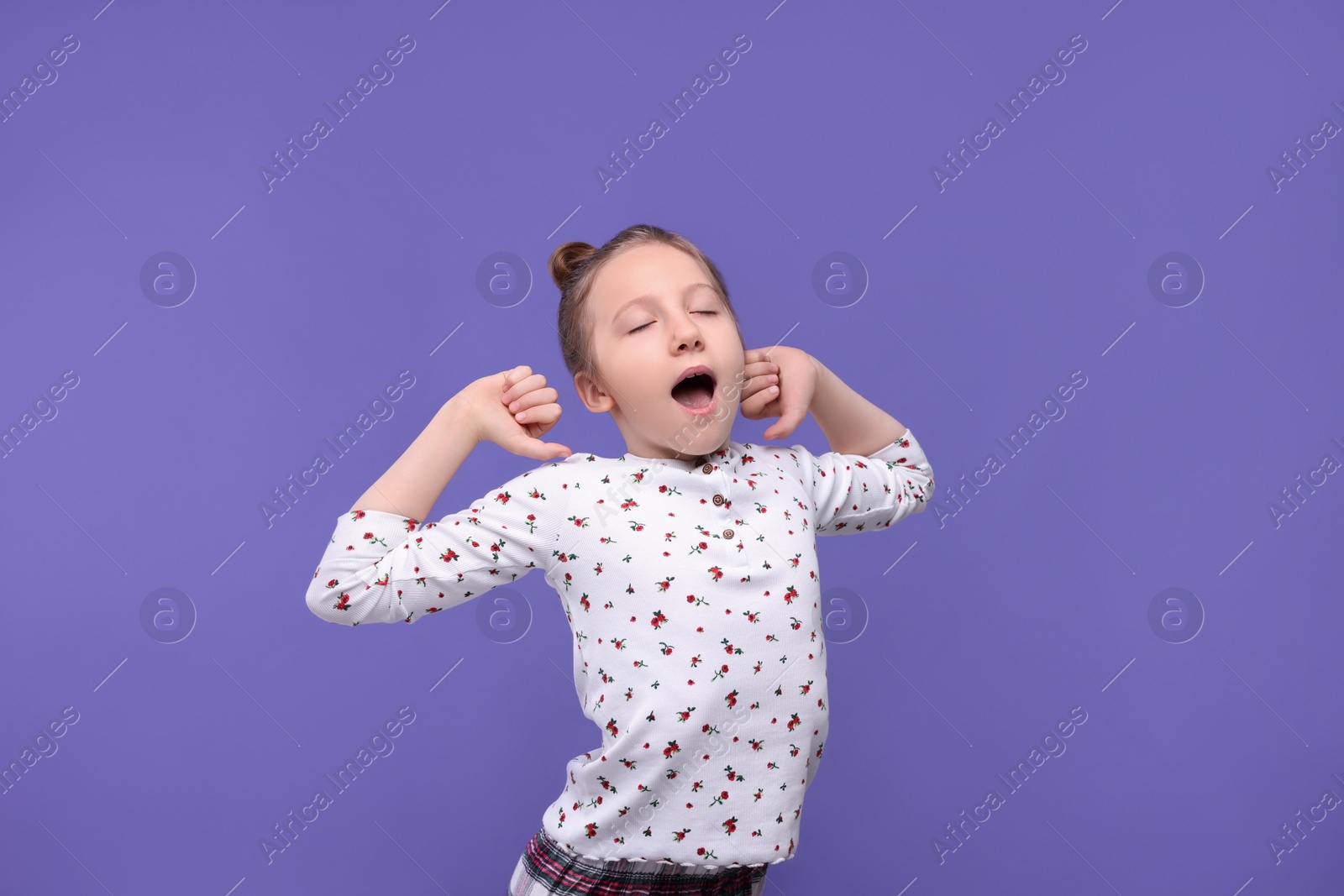 Photo of Sleepy girl yawning on purple background. Insomnia problem