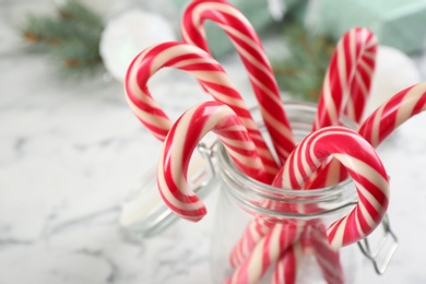 Photo of Sweet Christmas candy canes in glass jar, closeup