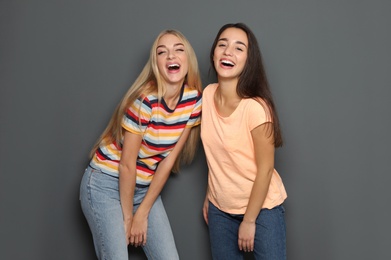 Photo of Young women laughing together against gray background