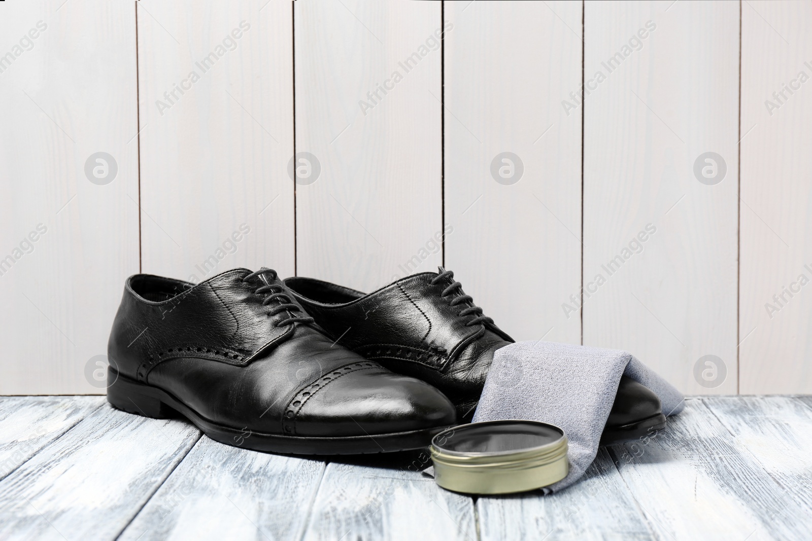 Photo of Leather footwear and shoe shine kit on white wooden surface