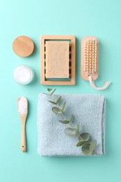 Jar of cream, body care products and eucalyptus branch on turquoise background, flat lay