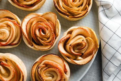 Freshly baked apple roses on grey table, flat lay. Beautiful dessert