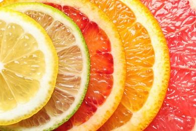 Slices of fresh citrus fruits as background, top view