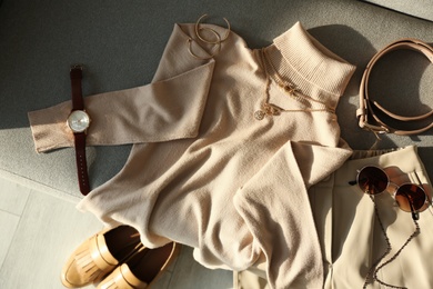 Soft cashmere sweater and accessories on sofa, flat lay