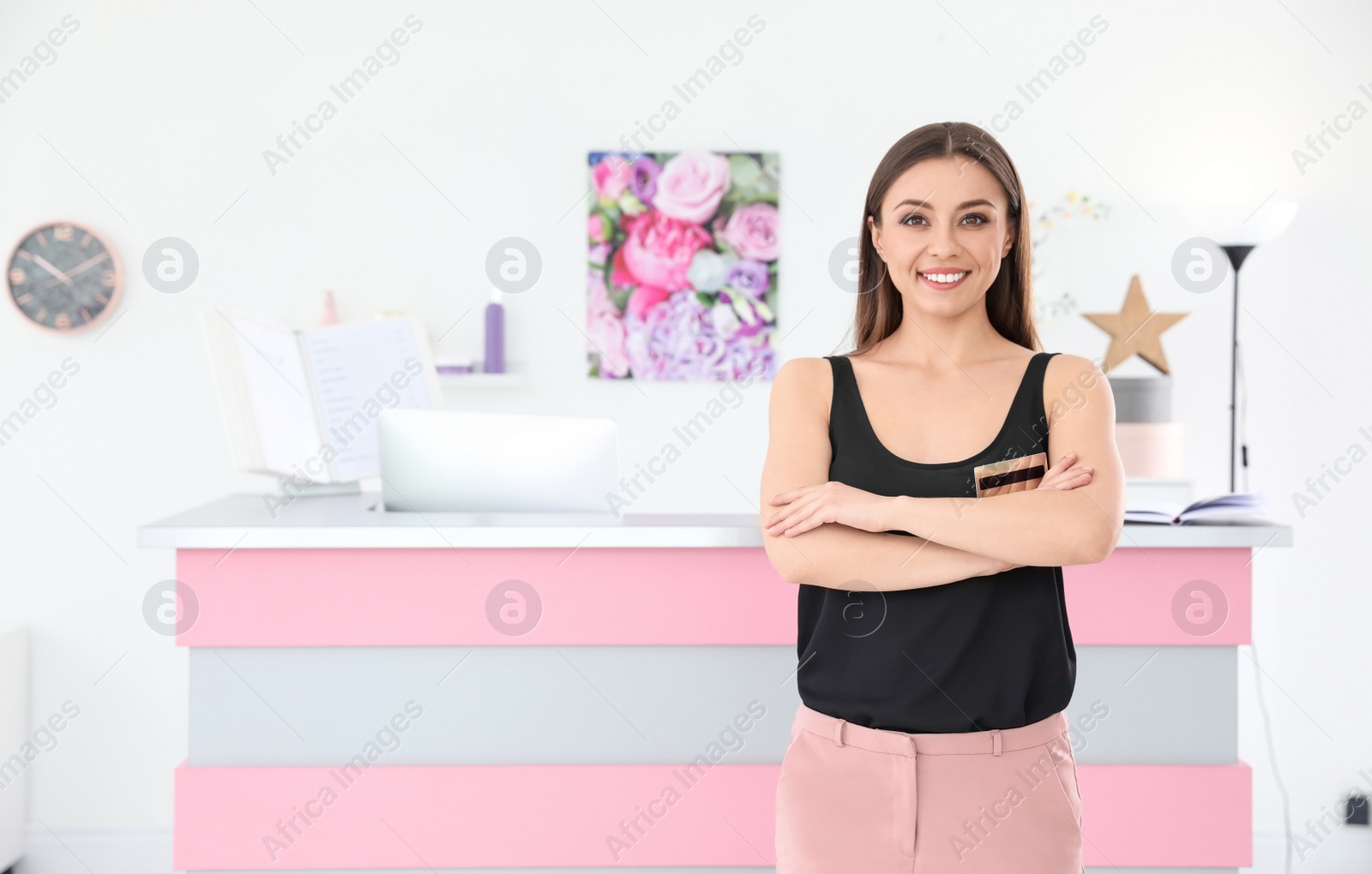 Photo of Young receptionist near desk in beauty salon