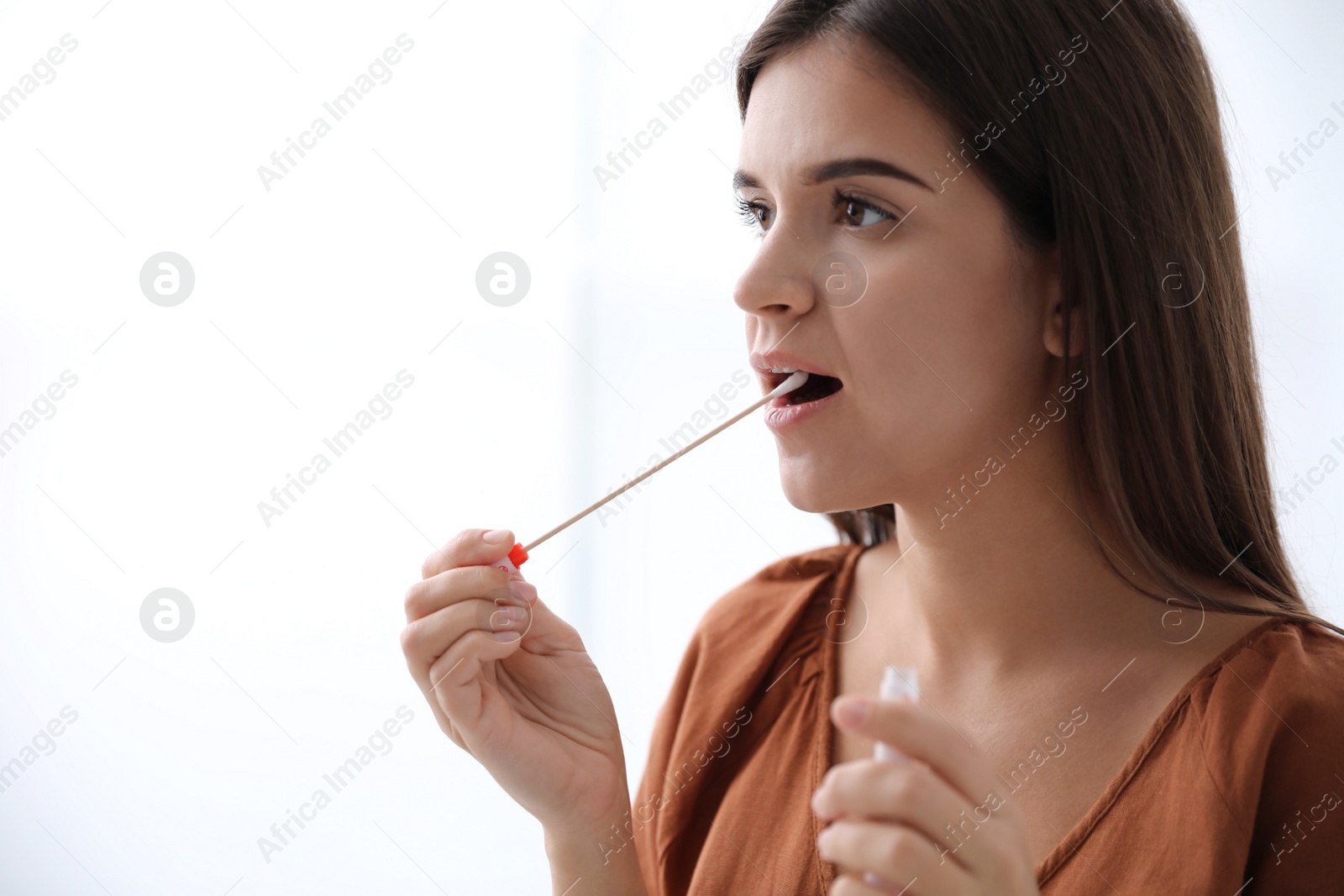 Photo of Woman taking sample for DNA test on light background