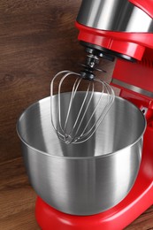 Photo of Modern red stand mixer on wooden table, closeup