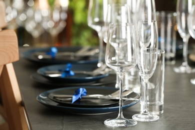 Photo of Table setting with empty glasses, plates and cutlery indoors