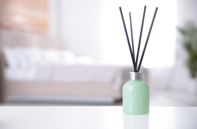 Reed air freshener on white table indoors. Space for text