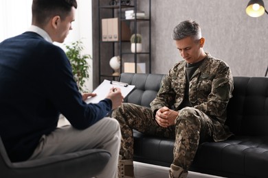 Professional psychotherapist working with military man in office