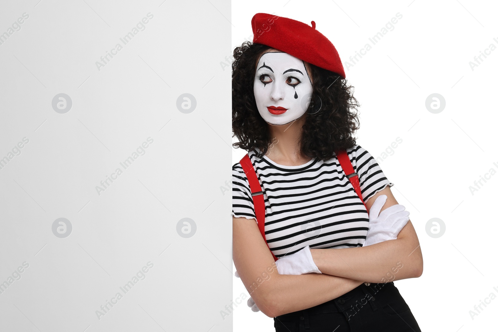 Photo of Funny mime with blank poster posing on white background