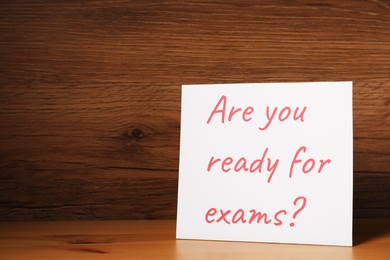 Photo of Card with question Are You Ready For Exams? on wooden table. Space for text