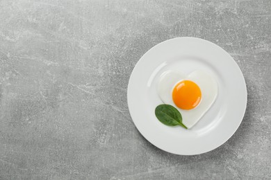 Photo of Romantic breakfast with fried egg on light grey table, top view. Space for text