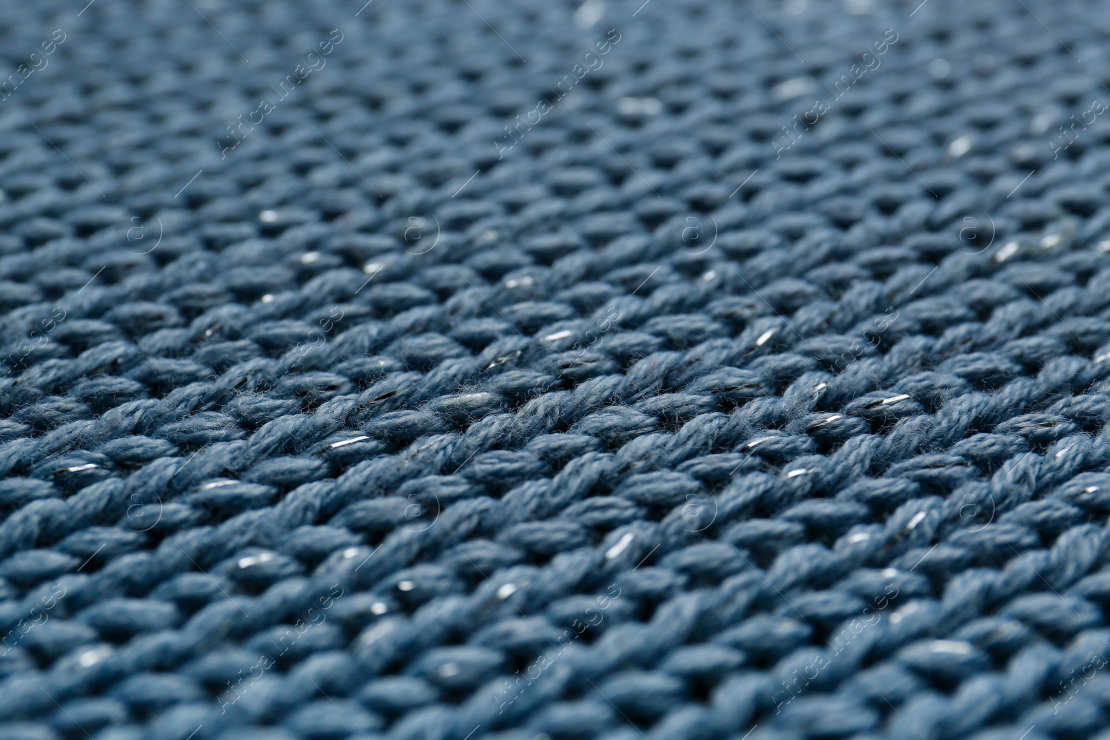 Photo of Beautiful pale blue knitted fabric as background, closeup