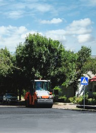 Image of Roller working on city street. Road repair