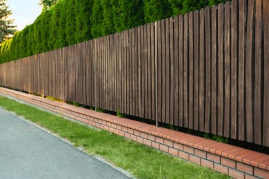 Photo of Green trees behind beautiful wooden fence outdoors