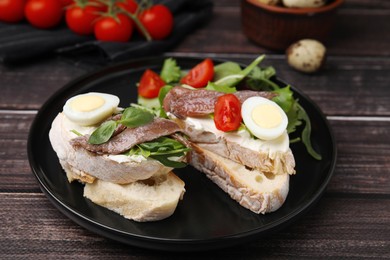 Photo of Delicious bruschettas with anchovies, cream cheese, arugula, eggs and tomatoes on wooden table, closeup