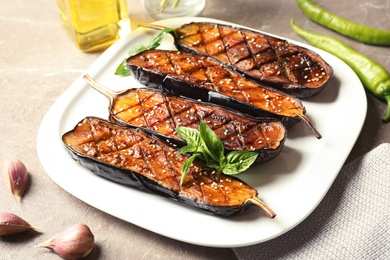 Plate with fried eggplant slices on table