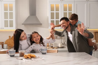 Happy family having breakfast at table in kitchen. Adoption concept