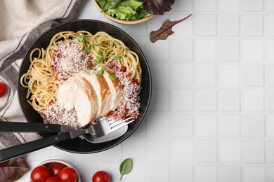 Photo of Delicious pasta with tomato sauce, chicken and parmesan cheese on white tiled table, flat lay. Space for text