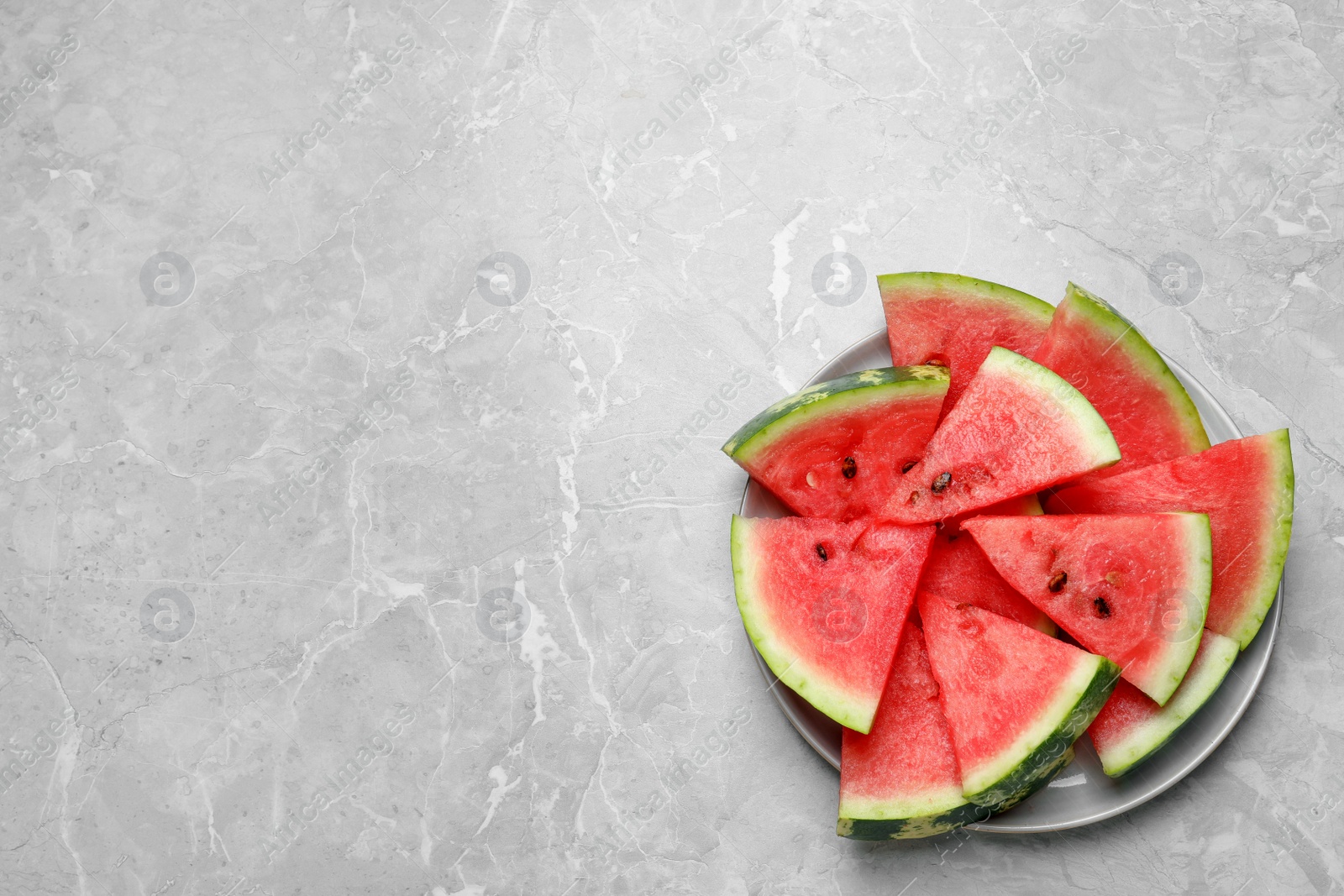 Photo of Slices of tasty ripe watermelon on light grey marble table, top view