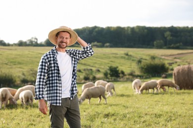 Smiling farmer and animals on pasture. Space for text