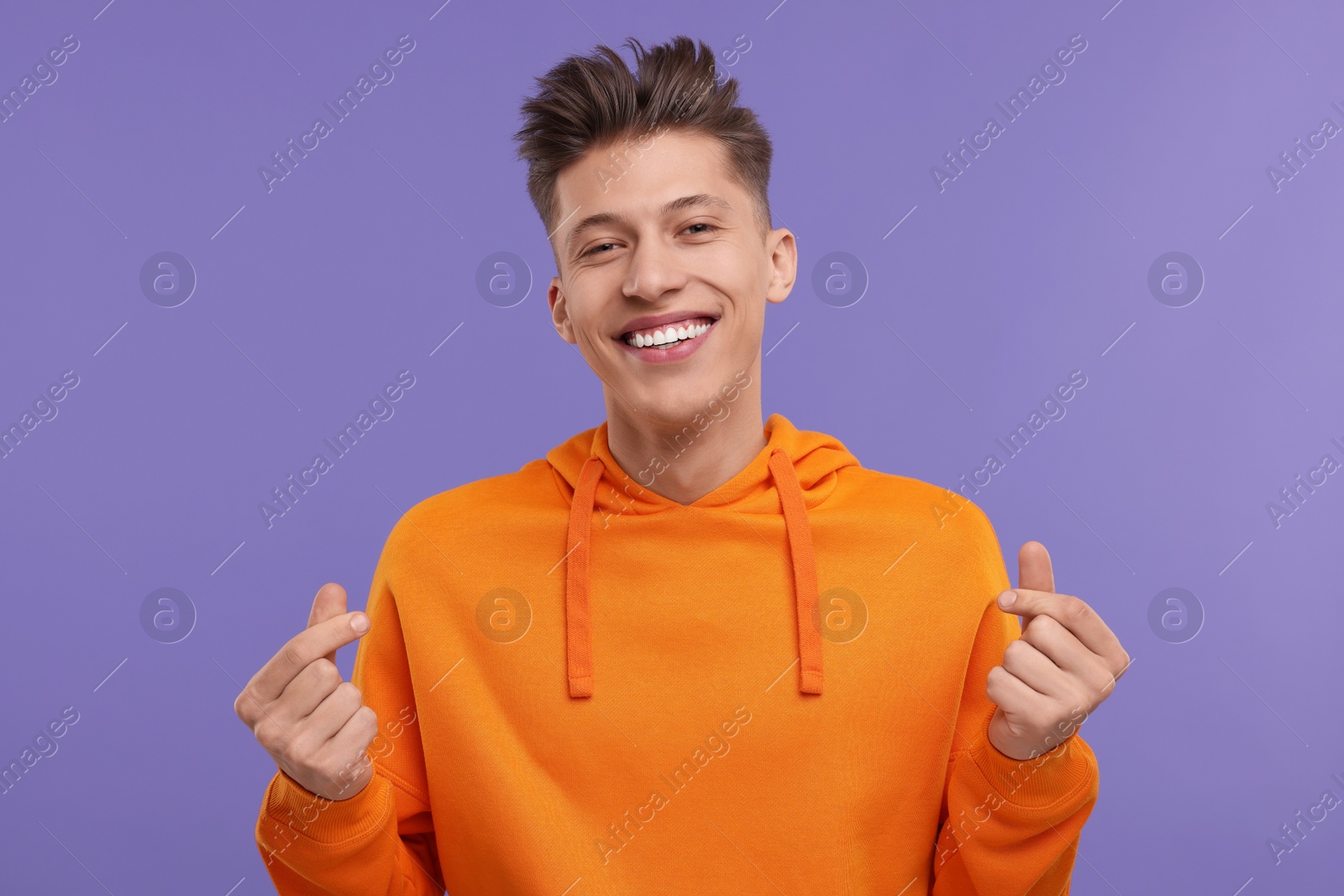 Photo of Happy man showing money gesture on purple background