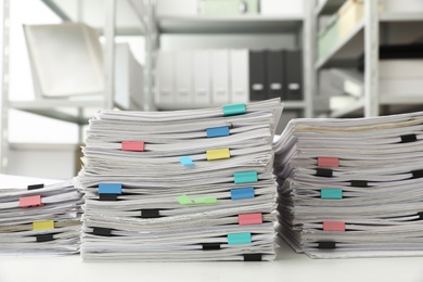 Stacks of documents with paper clips on office desk