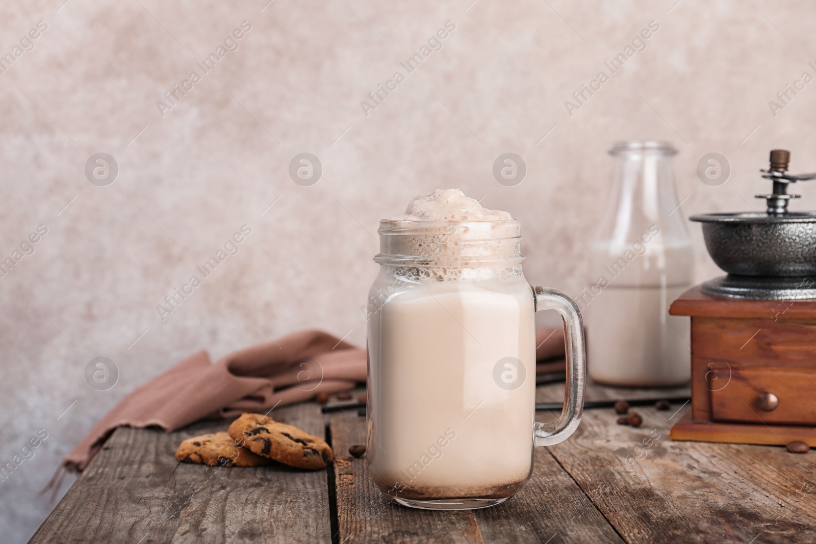 Photo of Mason jar with delicious milk shake on wooden table