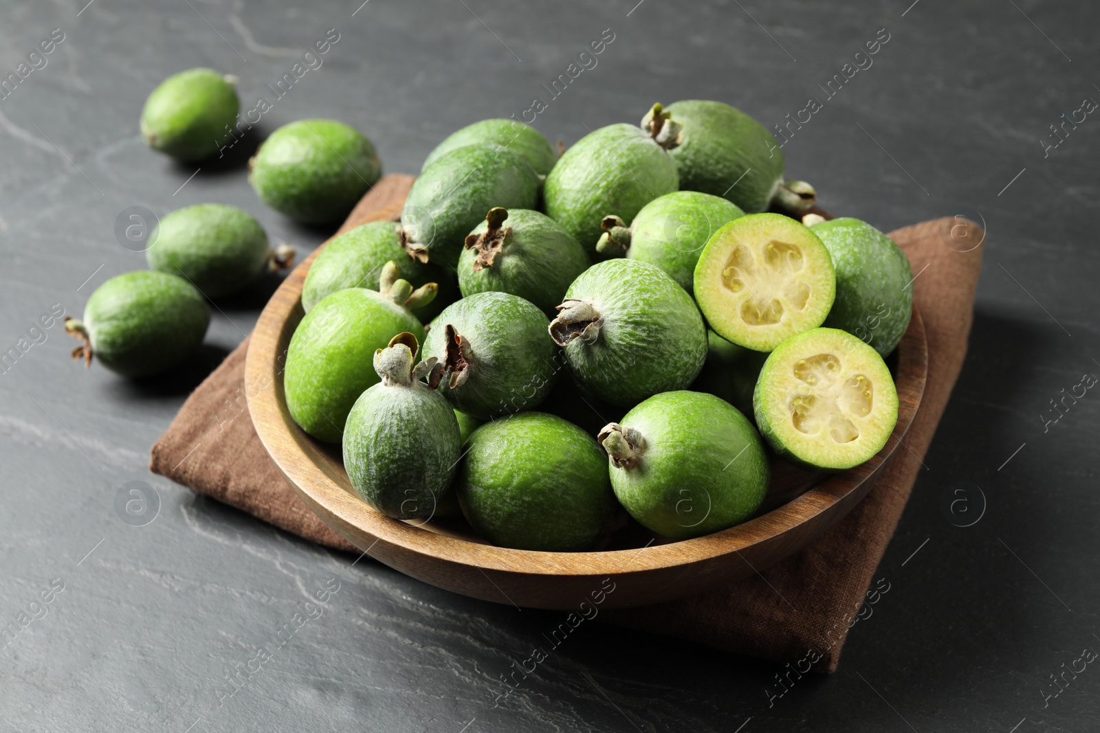 Photo of Delicious fresh feijoas on black table, closeup