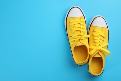 Photo of Pair of trendy sneakers on light blue background, flat lay. Space for text