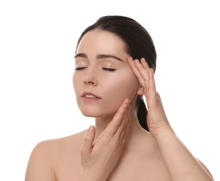 Photo of Young woman massaging her face on white background