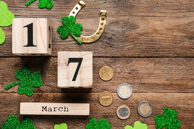 Flat lay composition with block calendar on wooden table, space for text. Saint Patrick's Day celebration
