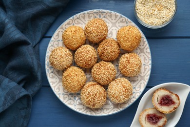 Photo of Delicious sesame balls on blue wooden table, flat lay