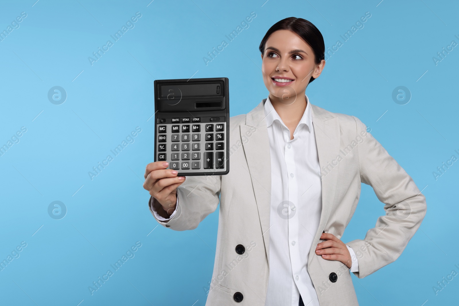 Photo of Smiling accountant with calculator on light blue background, space for text